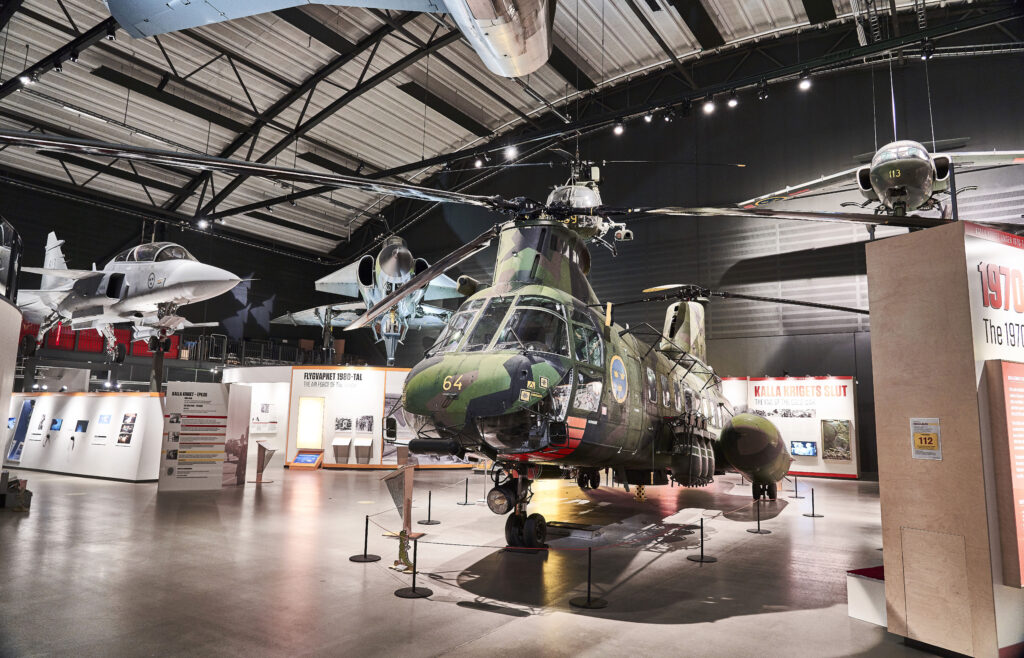 Helikopter HKP4, en kamouflagefärgad helikopter med flygvapnets blågula vapen med tre kronor på sidan.