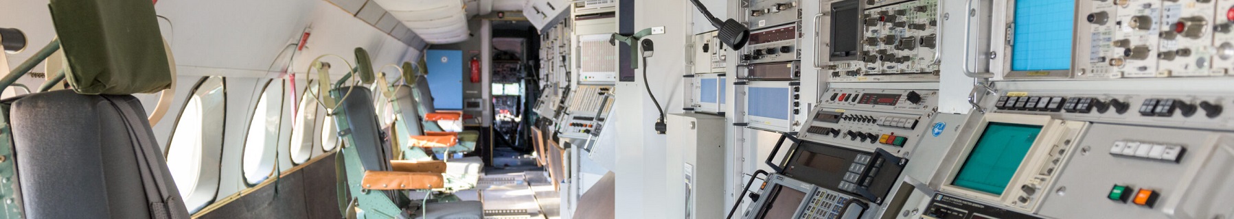 Insidan av ett flygplan av modell, TP 85 Caravelle ser inte ut som ett vanligt passagerarflygplan. Några enstaka stolar står längs ena sidan, med ryggen åt fönstren och vända mot andra sidan där radioutrustning finns.