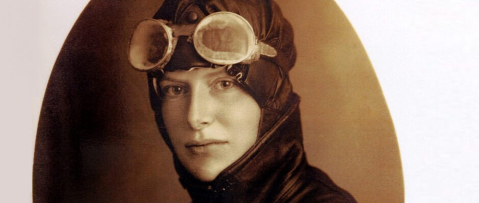 Ett gammalt foto av en kvinna i äldre pilotglasögon och skinnkläder.