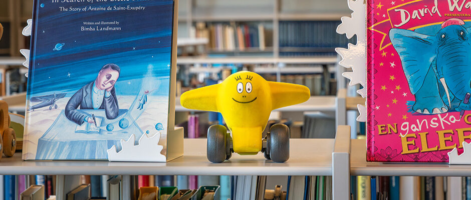 Seriefiguren Barbazoo i formen av ett flygplan st&aring;endes i en bokhylla i museets bibliotek