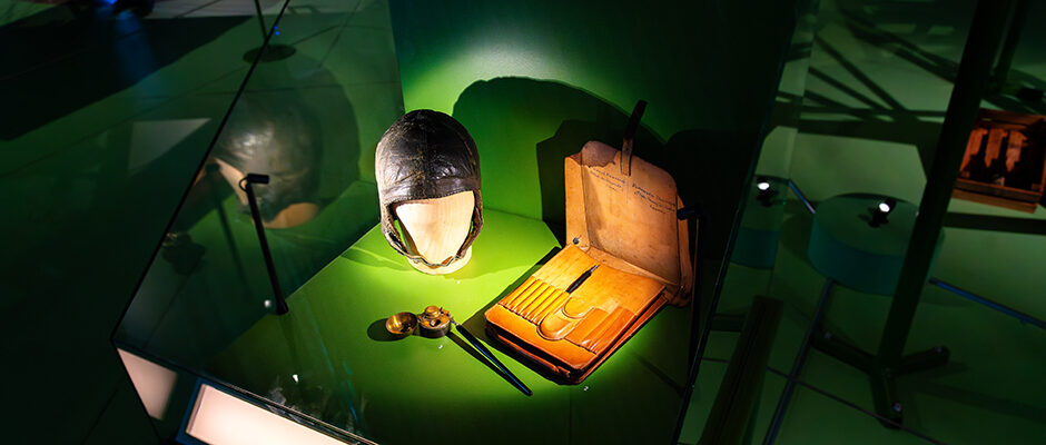 En monter med pilotm&ouml;ssa och ett skrivset, d&auml;ribland penna med bl&auml;ck