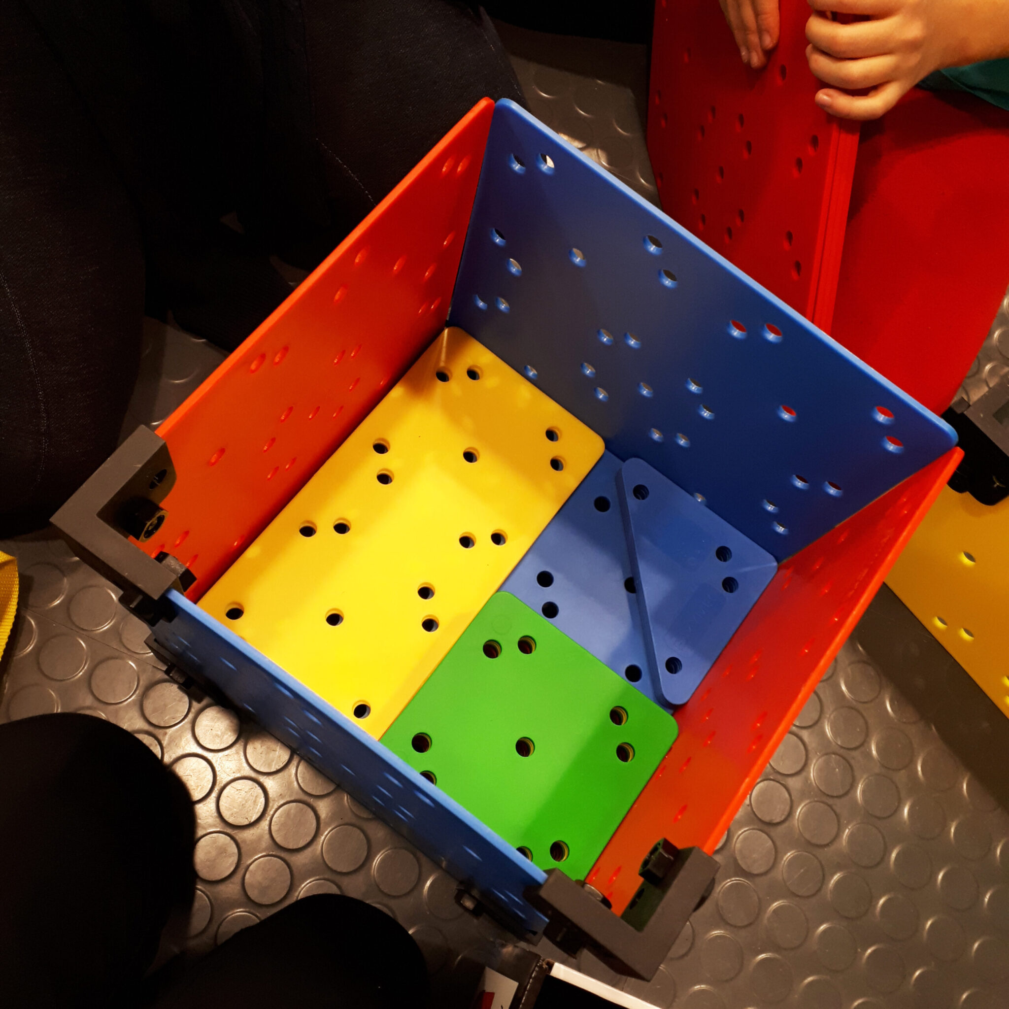 Byggplattor i olika f&auml;rger, form och storlek som formar en l&aring;da.